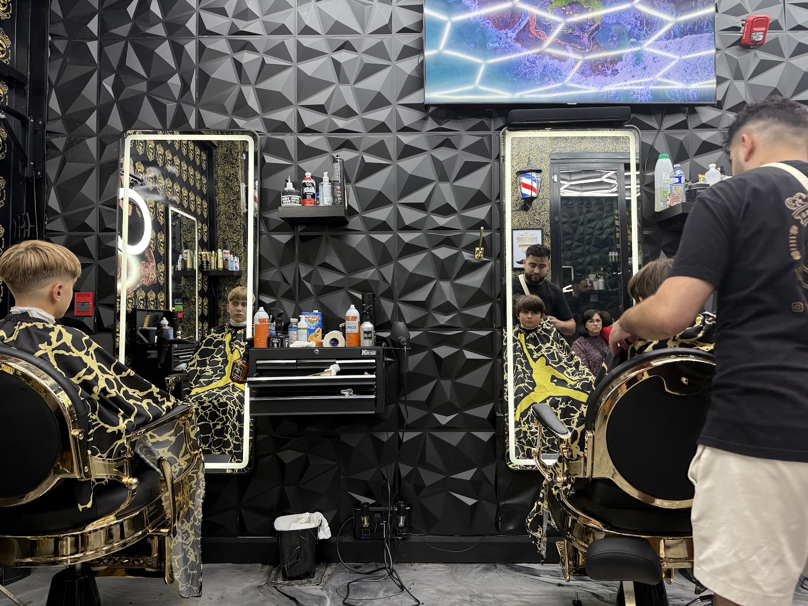 A barber lining up a client's cut inside Barbier Yaniso 2